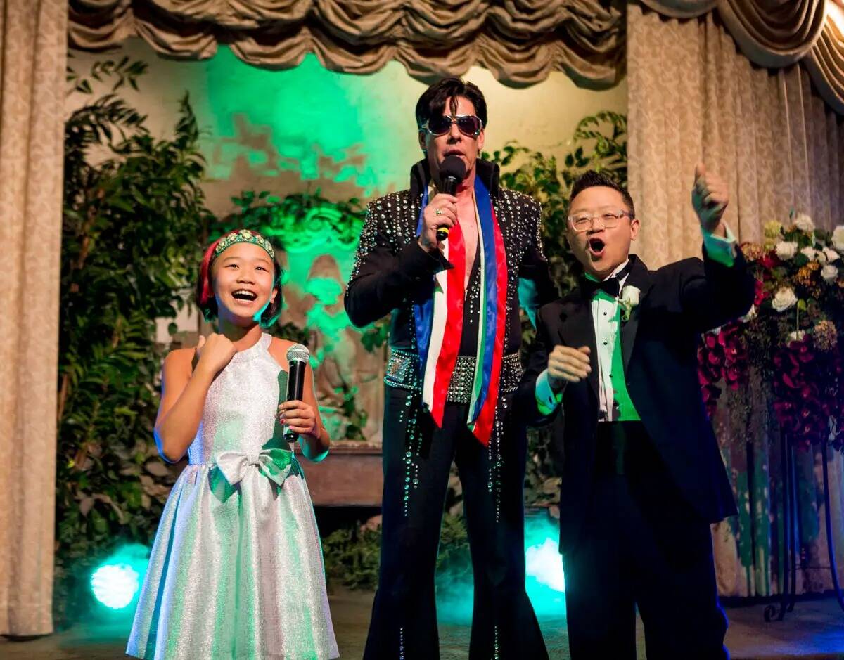 Garry Kim aplaude con su hija Lola durante su ceremonia con temática de Elvis para renovar sus ...
