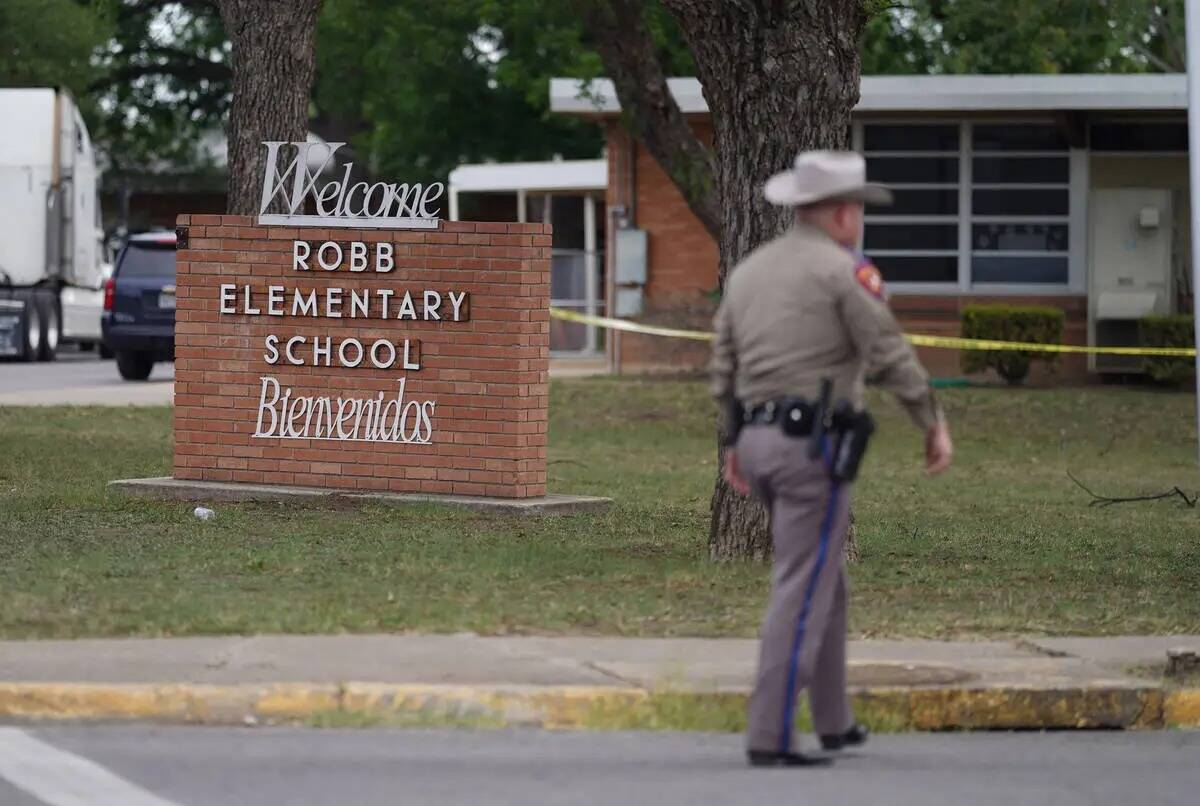 Un oficial camina fuera de Robb Elementary School en Uvalde, Texas, el martes 24 de mayo de 202 ...