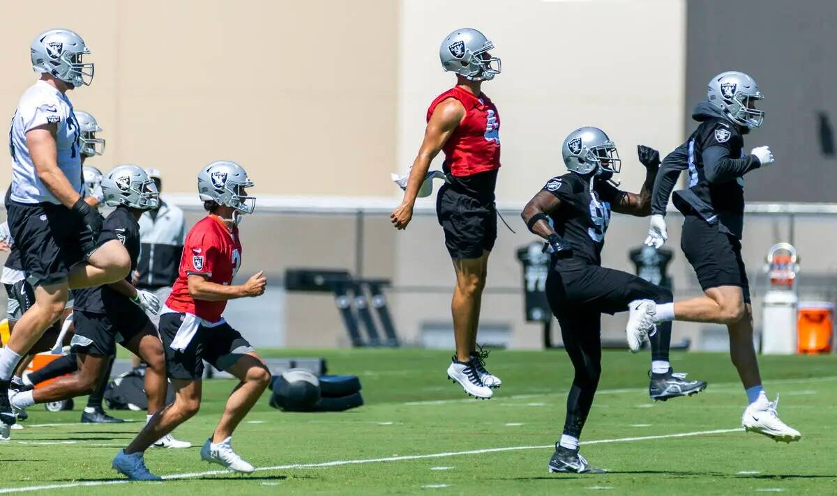 El quarterback de los Raiders, Derek Carr (4, centro), agarra aire durante la práctica del min ...