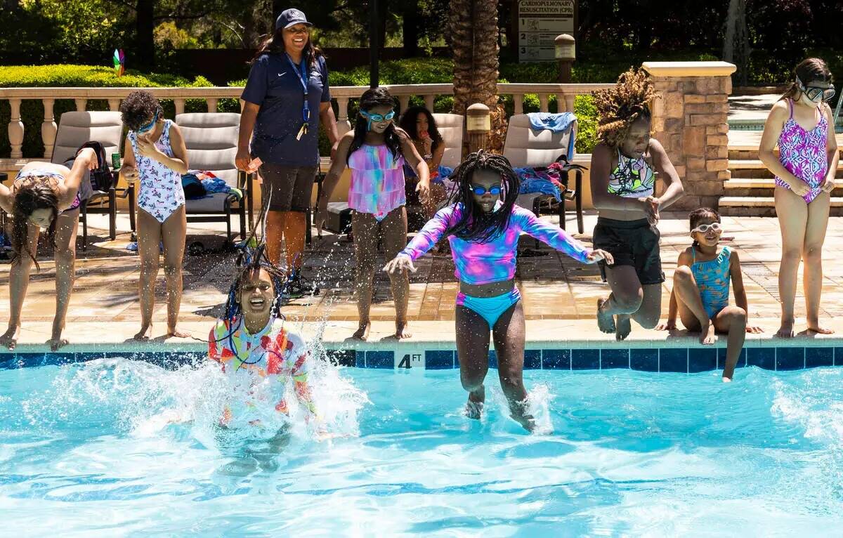 Niños saltan a la piscina durante un desayuno de panqueques y una fiesta en la piscina celebra ...