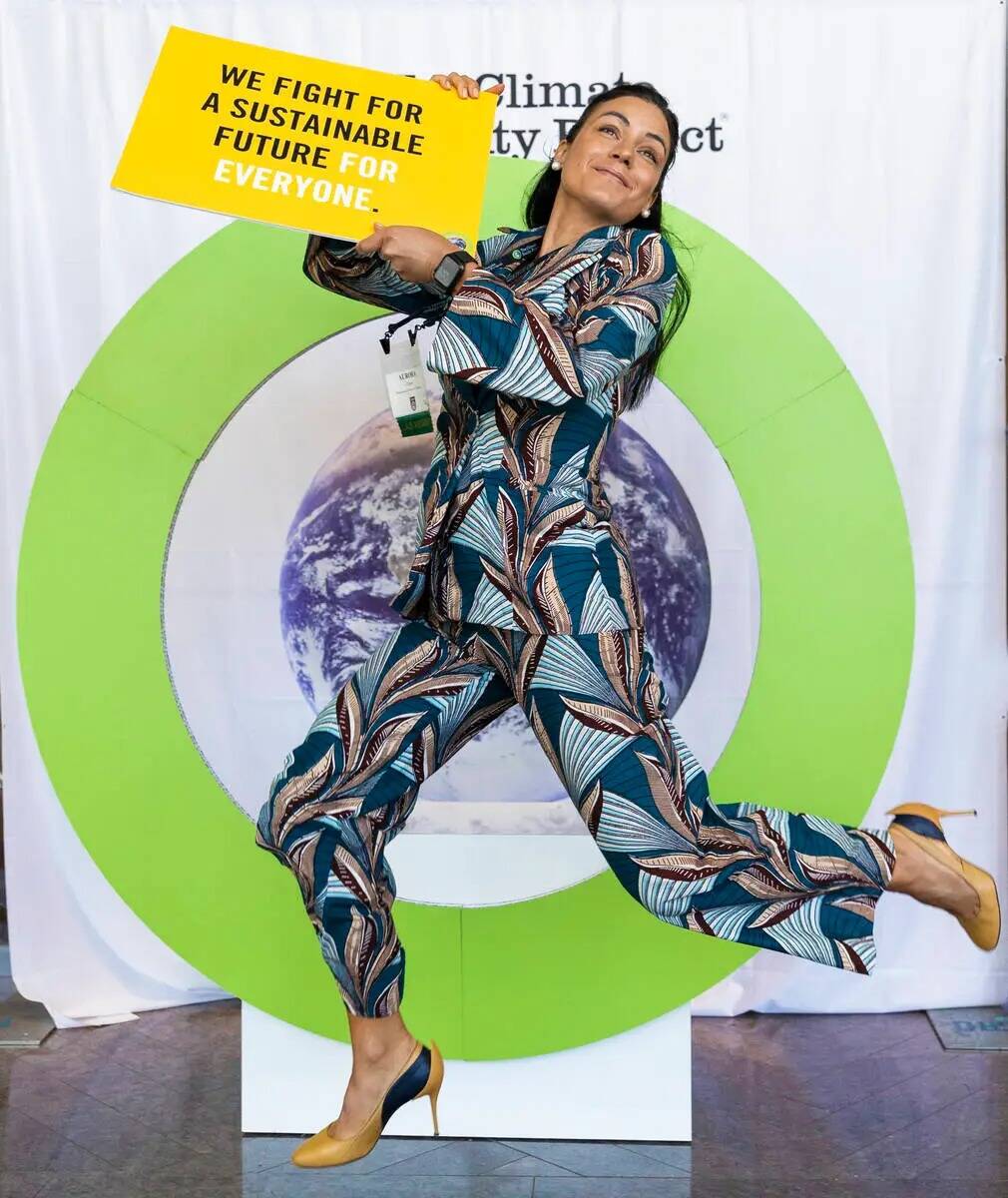 Aurora Chiste, de Washington, D.C., se toma una foto sosteniendo un cartel de sostenibilidad en ...