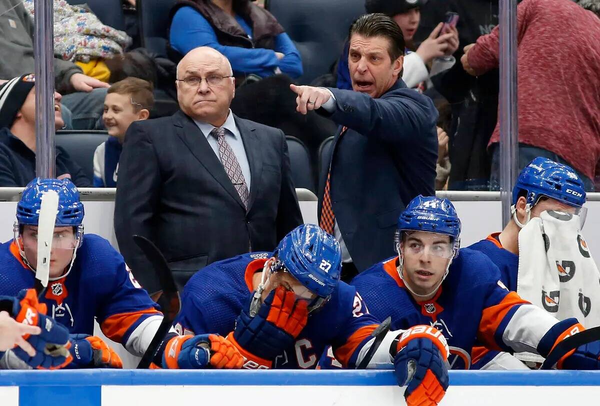 El entrenador principal de los New York Islanders, Barry Trotz, a la izquierda, y el entrenador ...