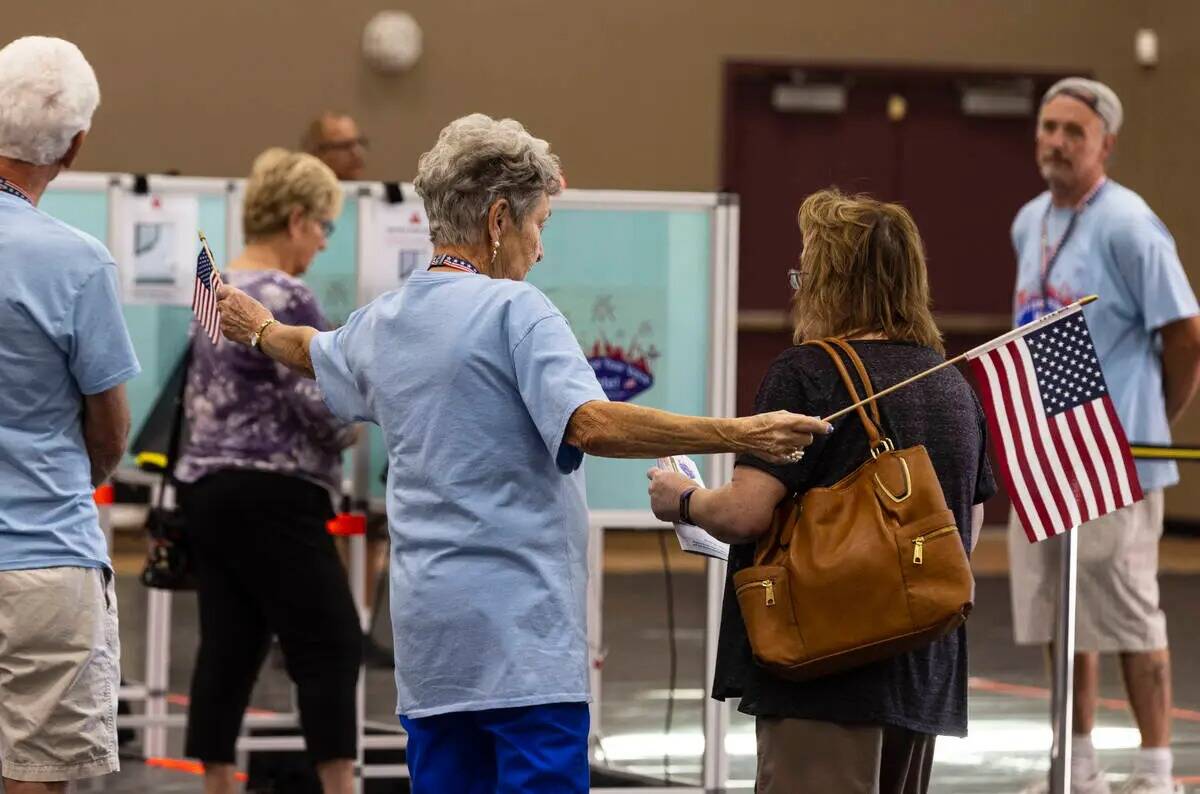 La voluntaria electoral Penny Busse saluda a una votante a su llegada a un centro de votación ...