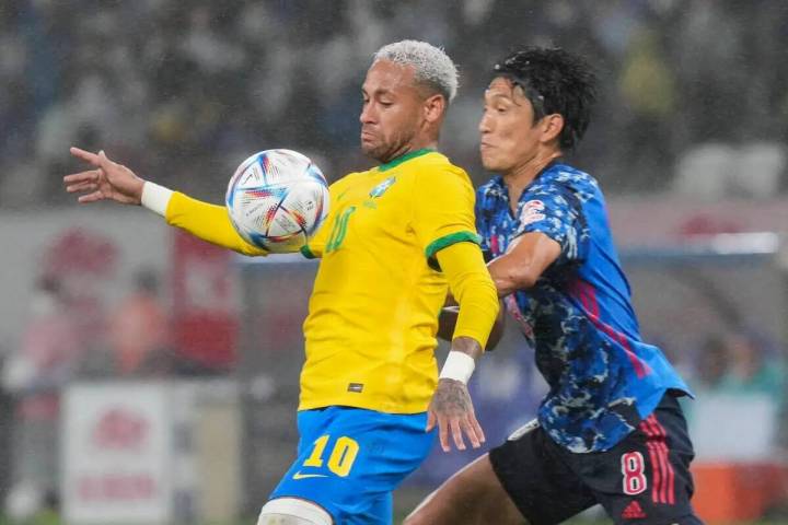 Neymar de Brasil, a la izquierda, lucha por el balón contra Genki Haraguchi de Japón durante ...