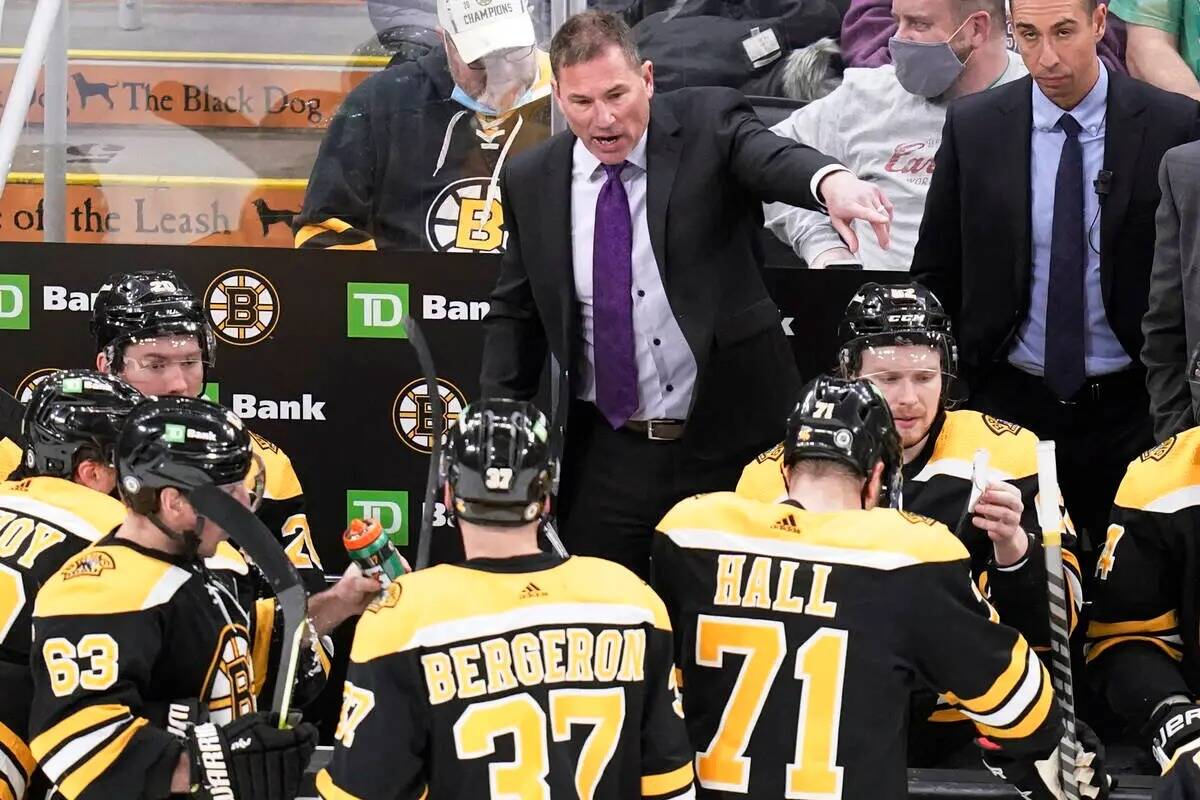 El entrenador de los Boston Bruins, Bruce Cassidy, arriba en el centro, habla con sus jugadores ...