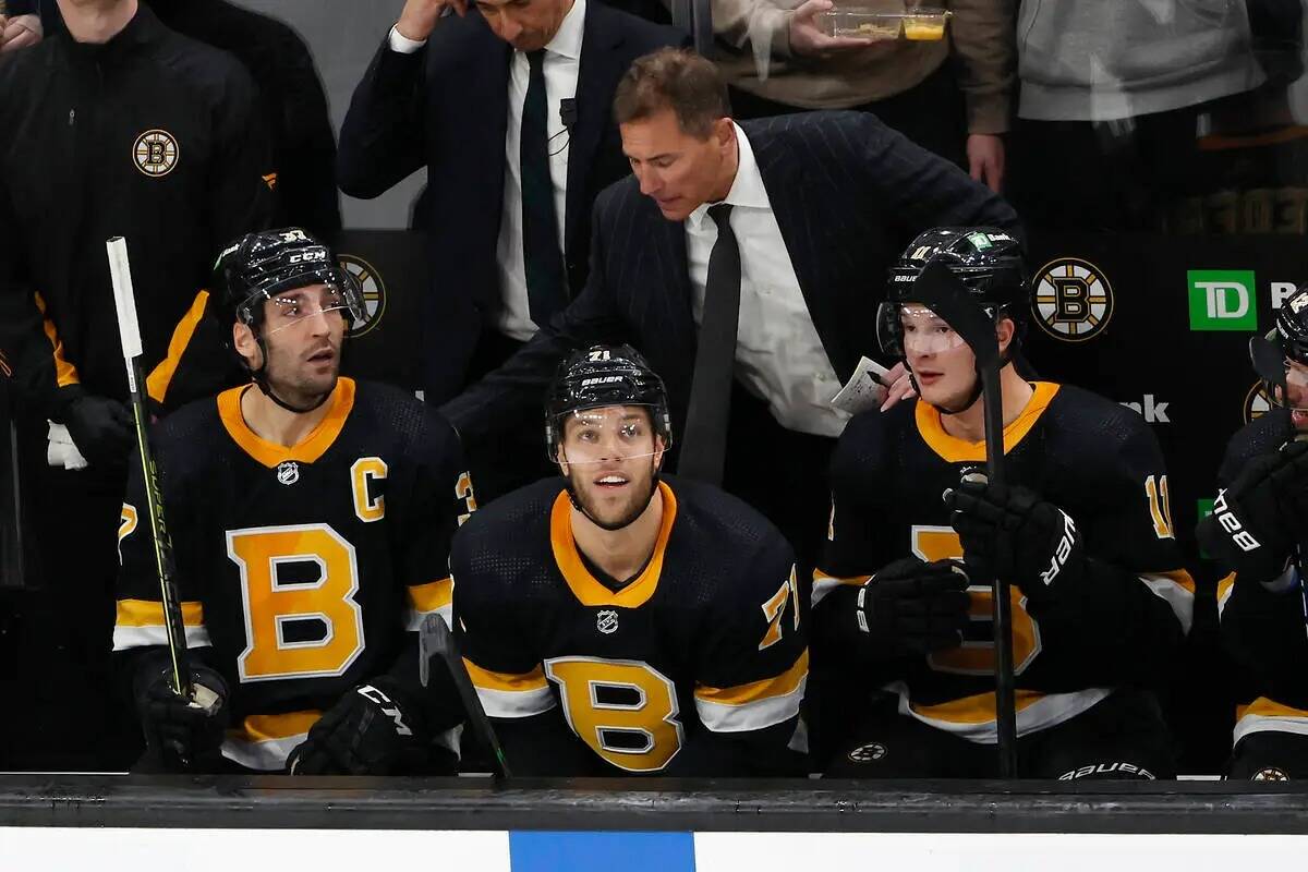 El entrenador de los Boston Bruins, Bruce Cassidy, arriba en el centro, felicita a Patrice Berg ...