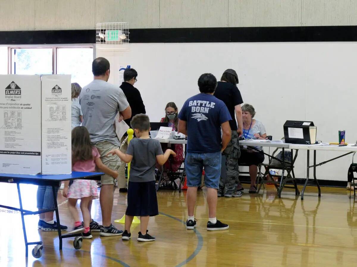 Votantes del Condado Washoe hacen fila en el gimnasio de la Reed High School en Sparks, Nevada, ...