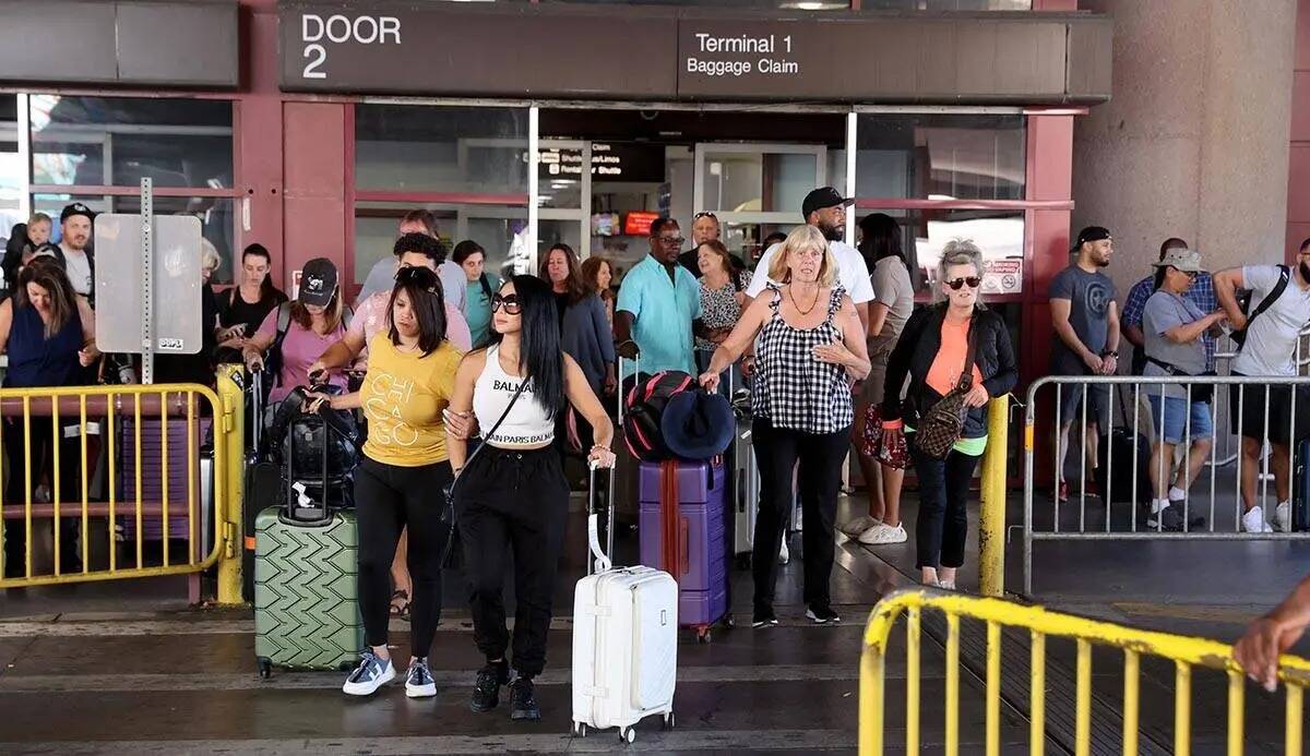 Los pasajeros salen del reclamo de equipajes en la Terminal 1 del Aeropuerto Internacional Harr ...