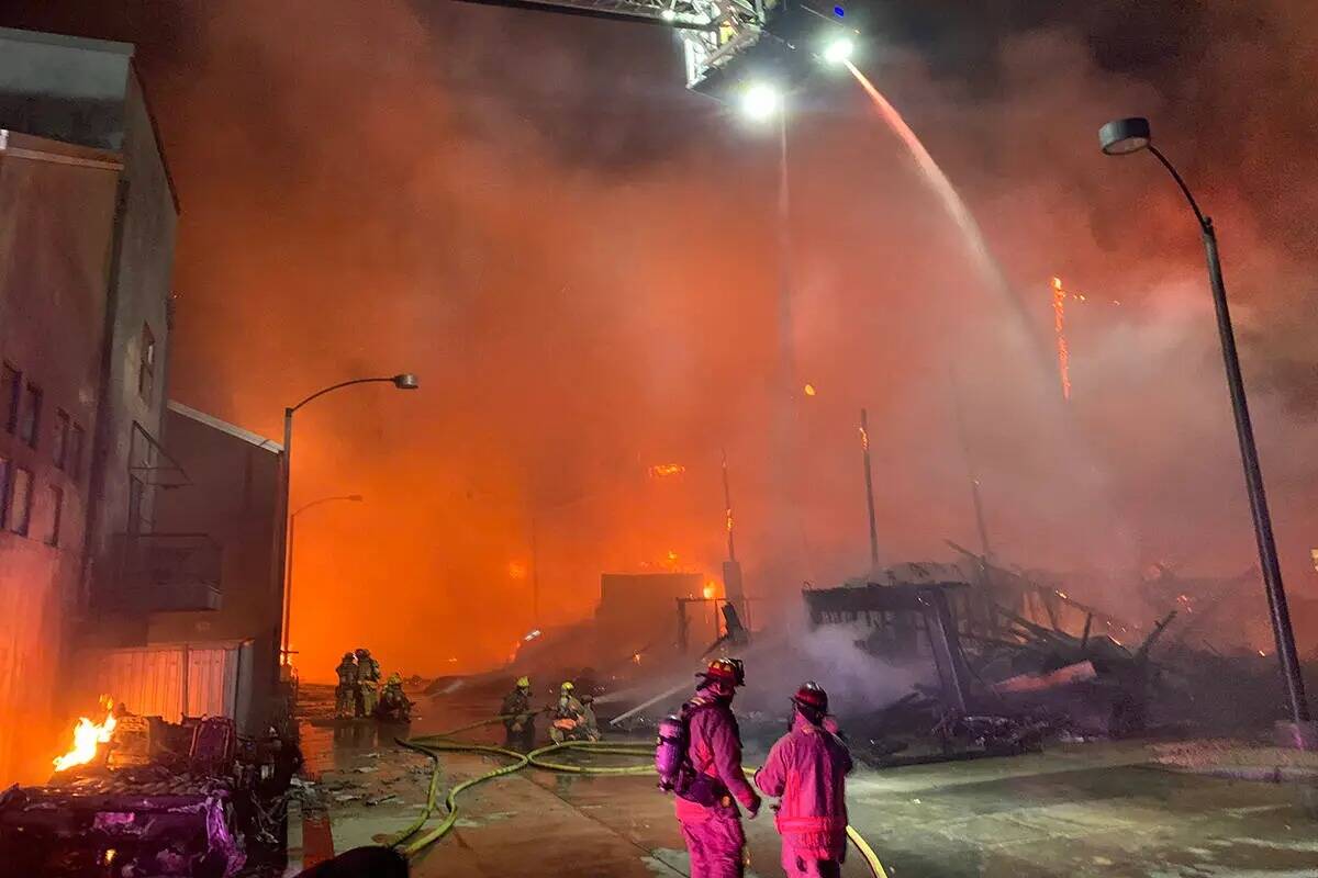 Los bomberos intentan extinguir un incendio, el domingo 19 de junio de 2022, en el centro de La ...