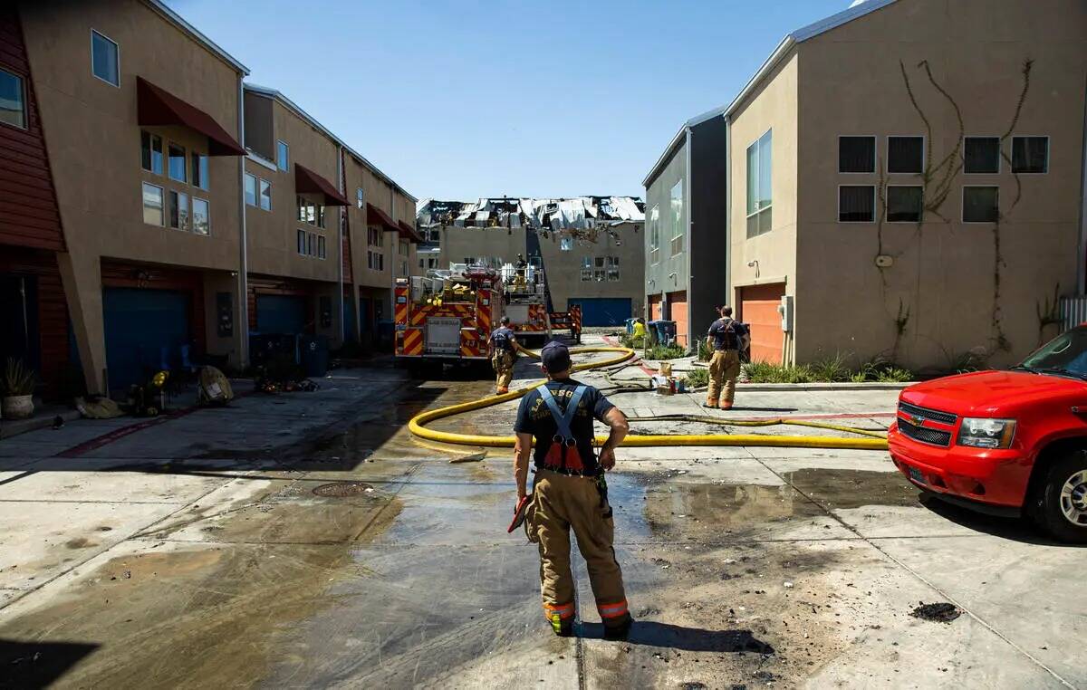 Un bombero inspecciona la escena donde un incendio dañó o destruyó al menos 10 edificios de ...
