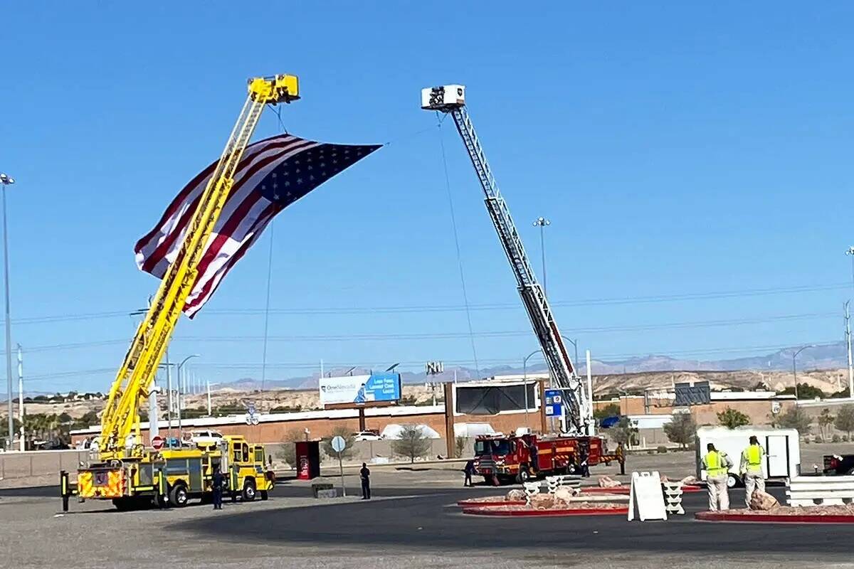 Miembros de los departamentos de bomberos de Las Vegas y del Condado Clark extienden una bander ...