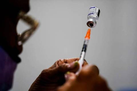 ARCHIVO - Se prepara una jeringa con la vacuna contra COVID-19 de Pfizer en una clínica de vac ...