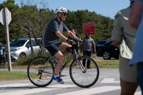 El presidente Joe Biden pedalea su bicicleta hacia una multitud en Gordons Pond en Rehoboth Bea ...