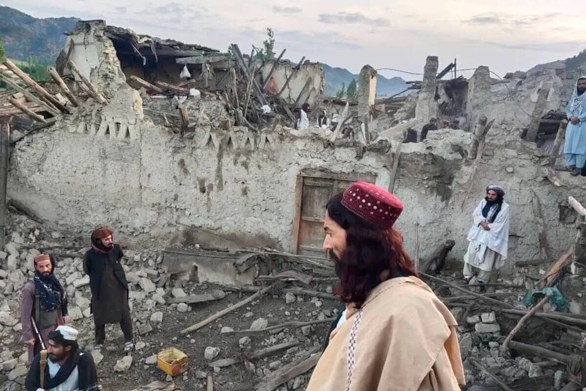 En esta foto publicada por la agencia de noticias estatal Bakhtar, afganos observan la destrucc ...