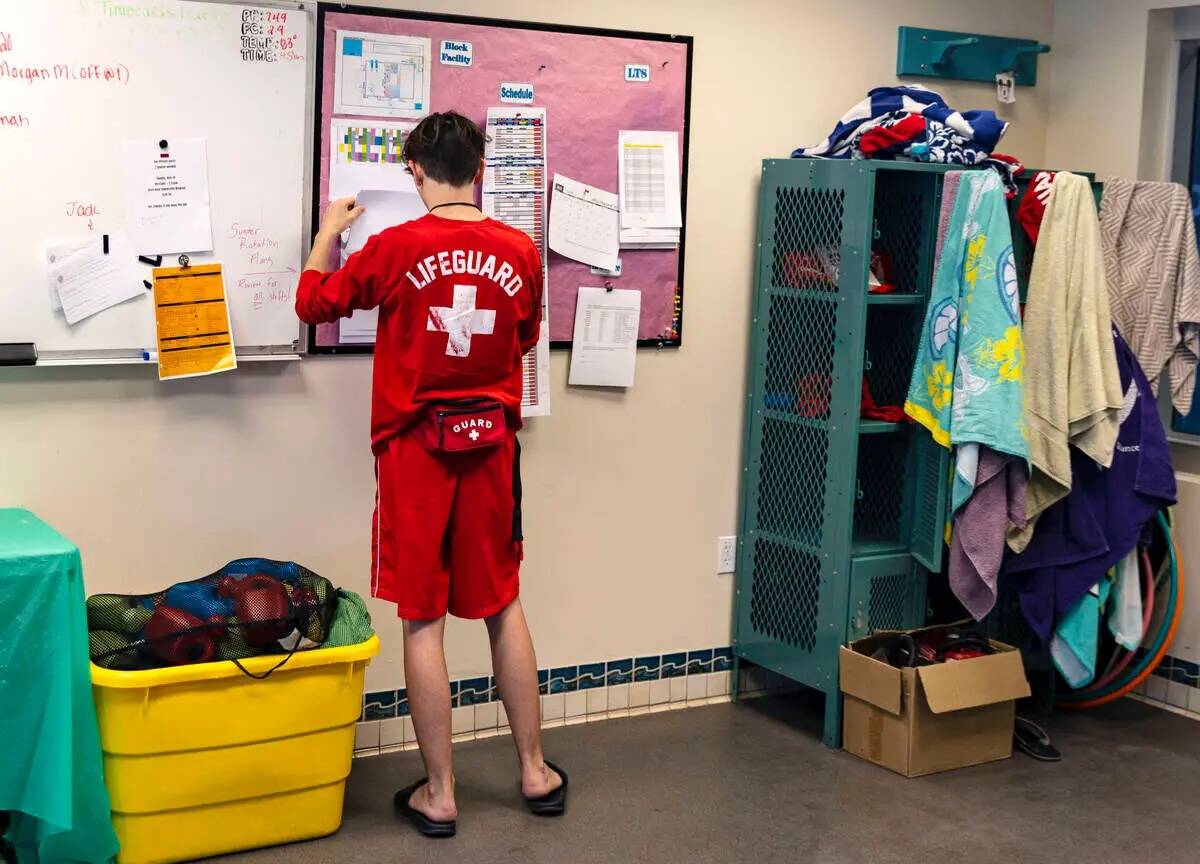 Aiden Ruggiutz, de 18 años, salvavidas, revisa su horario dentro de la caseta de salvavidas en ...