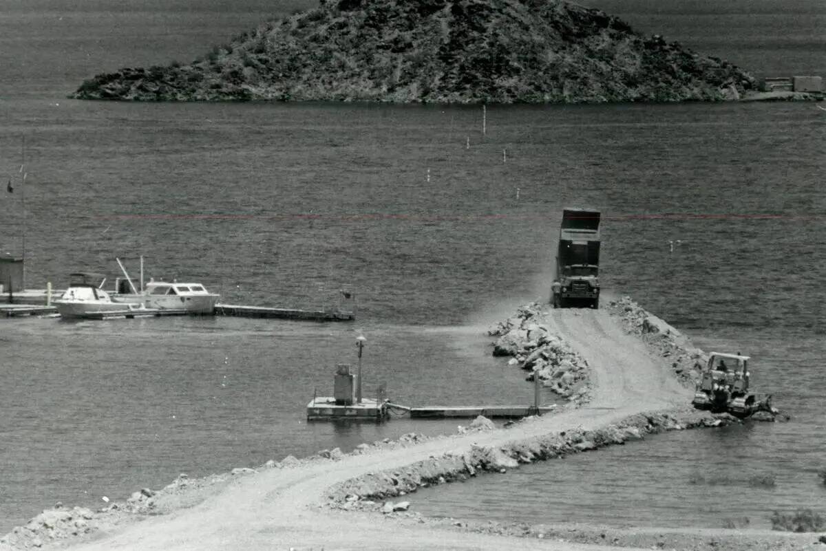 Los trabajadores reconstruyen un camino sumergido hacia una isla cerca del Lake Mead Marina el ...