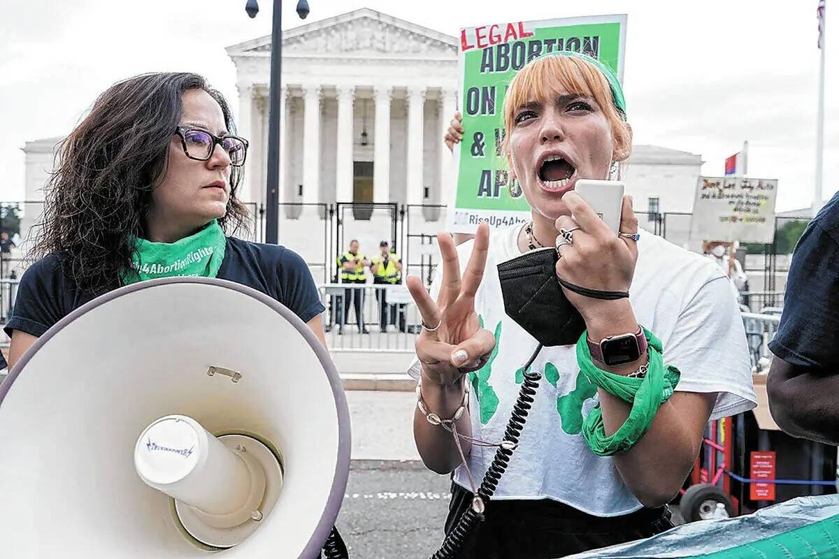 Activistas del derecho al aborto reaccionan ante el Tribunal Supremo en Washington, el viernes ...