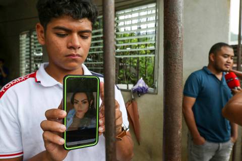 Jaser Daniel Ortíz muestra una foto de su madre Nayarith Bueso en El Progreso, Honduras, el ju ...