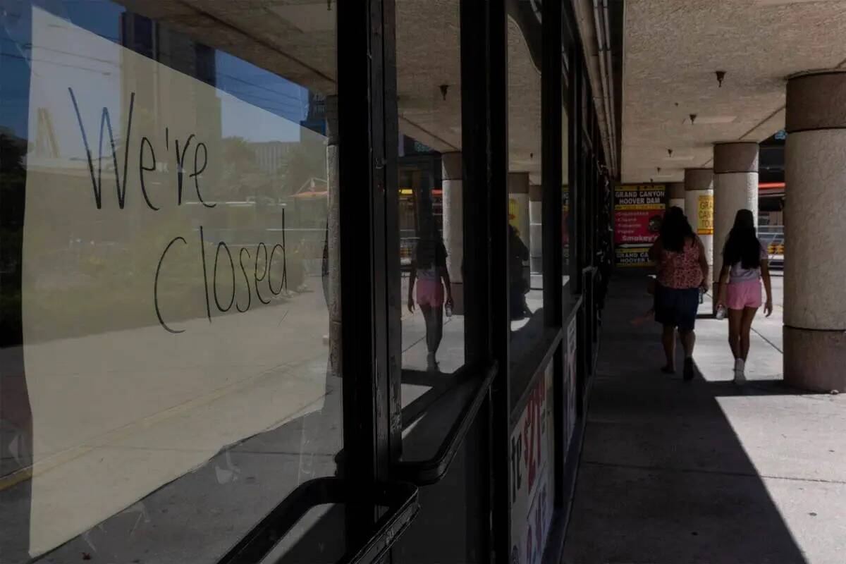 Peatones pasan por delante de las tiendas cerradas en el Cable Center Shops, el miércoles 29 d ...