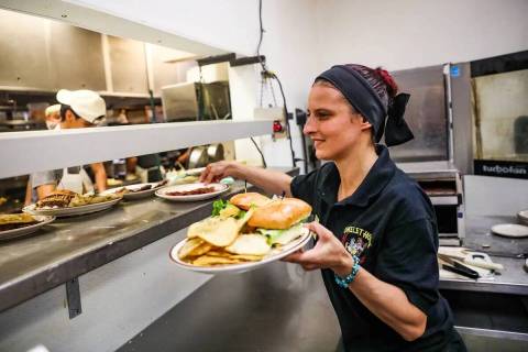 La mesera Brittney Crocker toma comida para servirla en The Omelet House, en su ubicado en el c ...