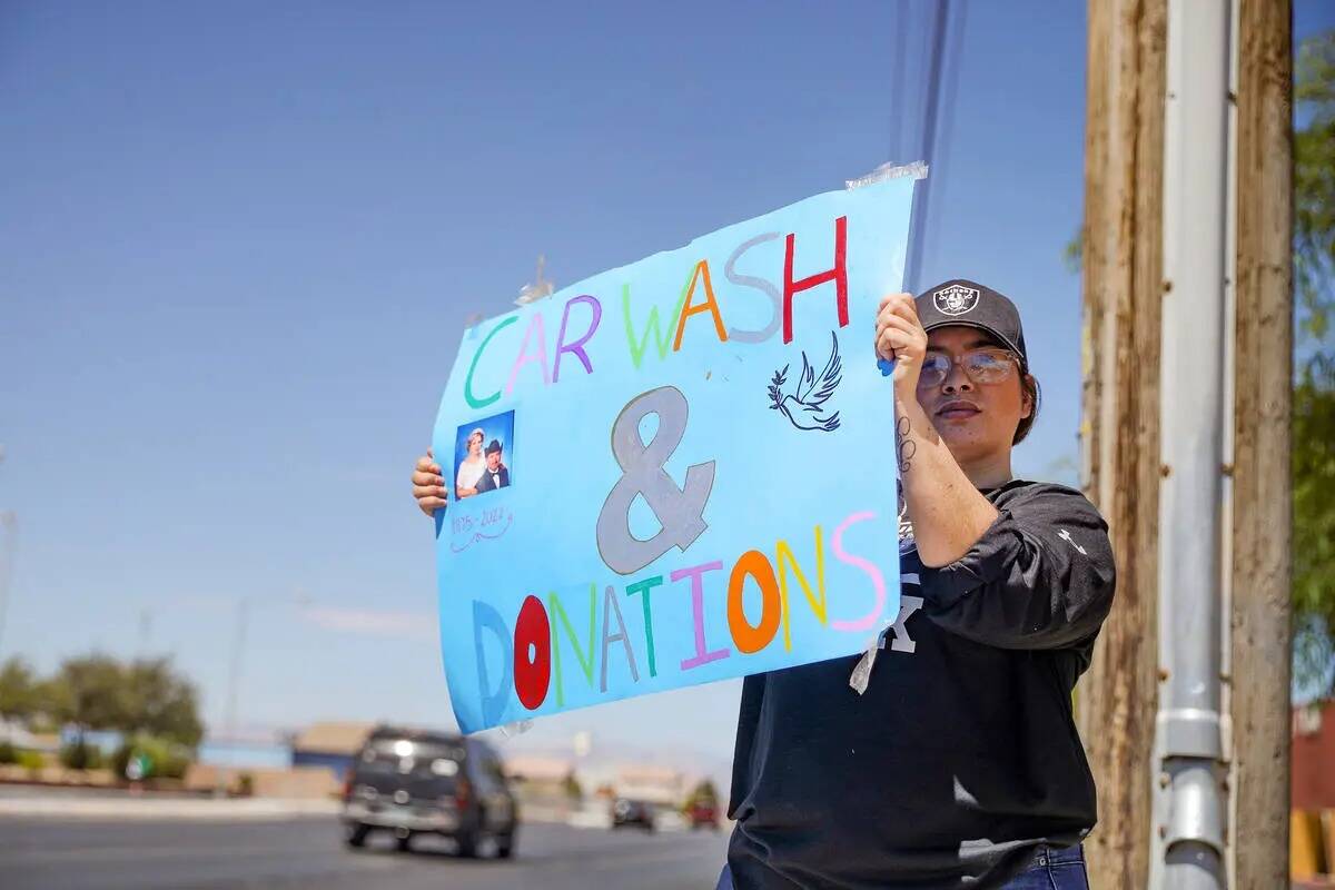 Griselda Gallarzo sostiene letreros para un lavado de autos para recaudar fondos para el entier ...