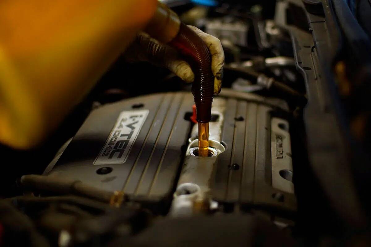 Un mecánico llena de aceite un auto en un taller de reparación de automóviles, el miércoles ...