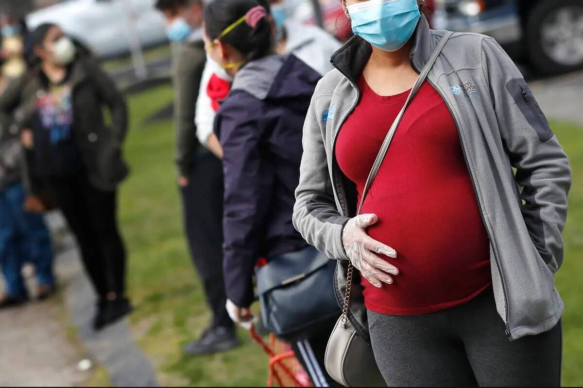 ARCHIVO - En esta foto de archivo del 7 de mayo de 2020, una mujer embarazada con cubrebocas y ...