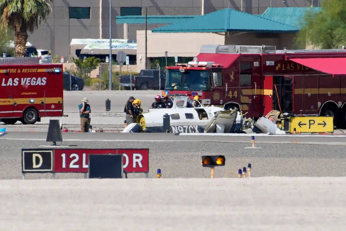 Oficiales investigan los restos de un avión en el sitio de un accidente fatal en el aeropuerto ...
