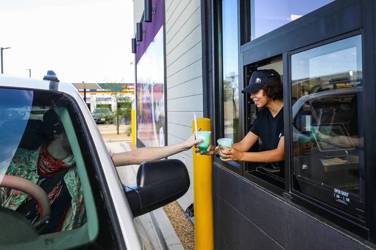La empleada Emmalise Reed entrega una bebida a un cliente en un nuevo Taco Bell "Go Mobile" que ...