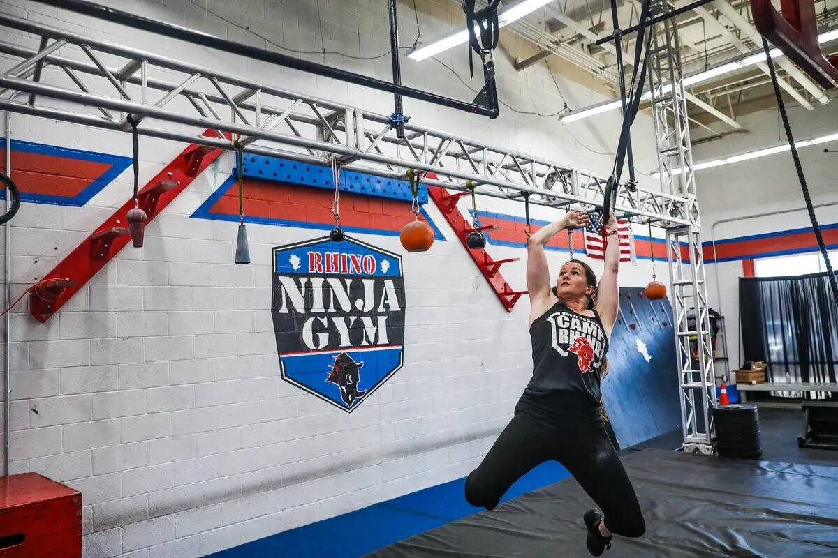 La propietaria Julie Johnston se balancea en una pista de obstáculos en Rhino Ninja Gym en Las ...