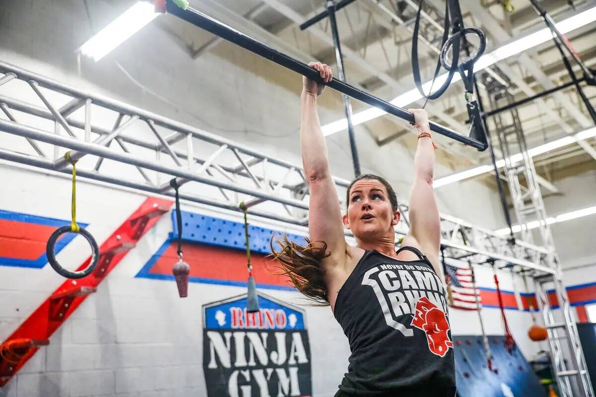 La propietaria Julie Johnston se balancea en una pista de obstáculos en el Rhino Ninja Gym en ...