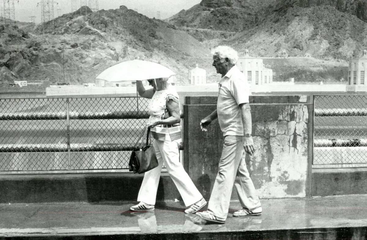 Turistas caminan por el lado de Arizona del desagüe de la Presa Hoover el 21 de julio de 1983. ...