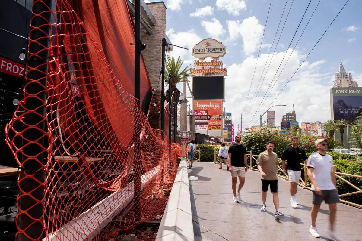 Peatones caminan por el Hawaiian Marketplace cerrado en Las Vegas Boulevard el lunes 25 de juli ...