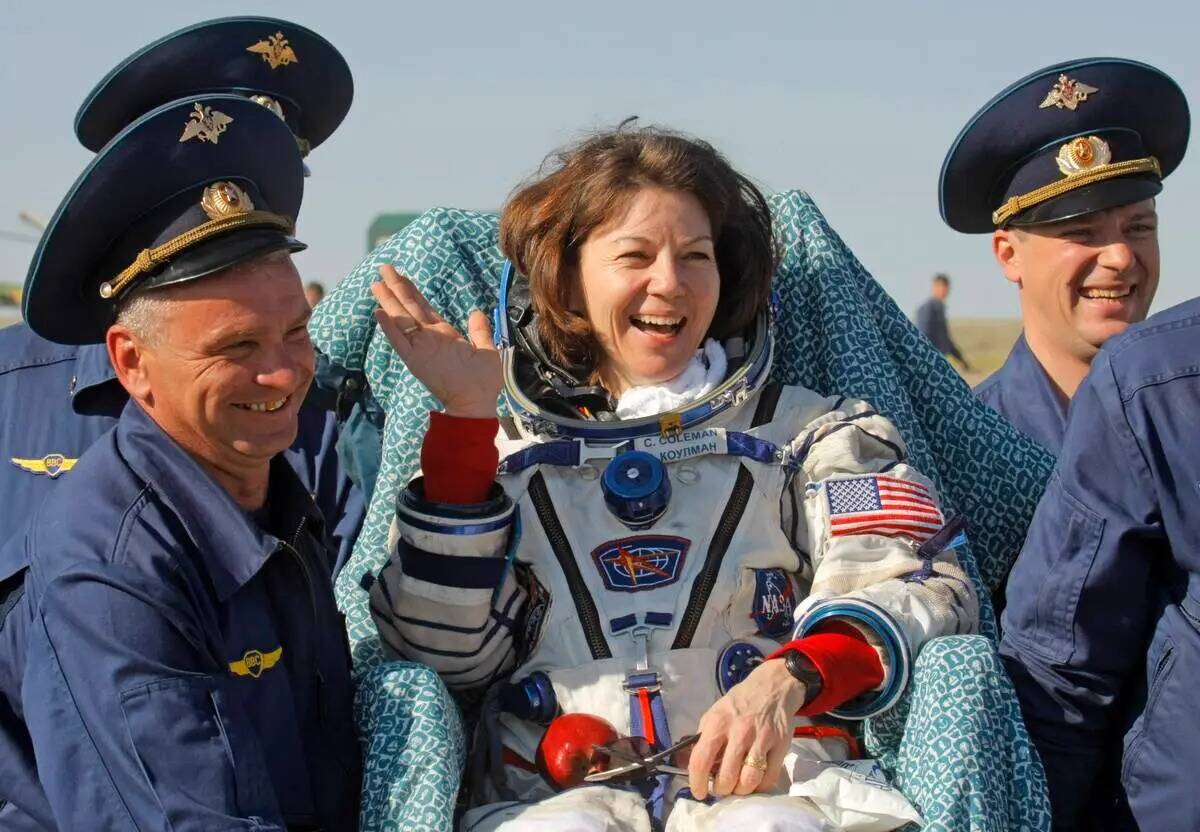 ARCHIVO - Miembros del equipo de rescate de la agencia espacial rusa llevan a la astronauta est ...