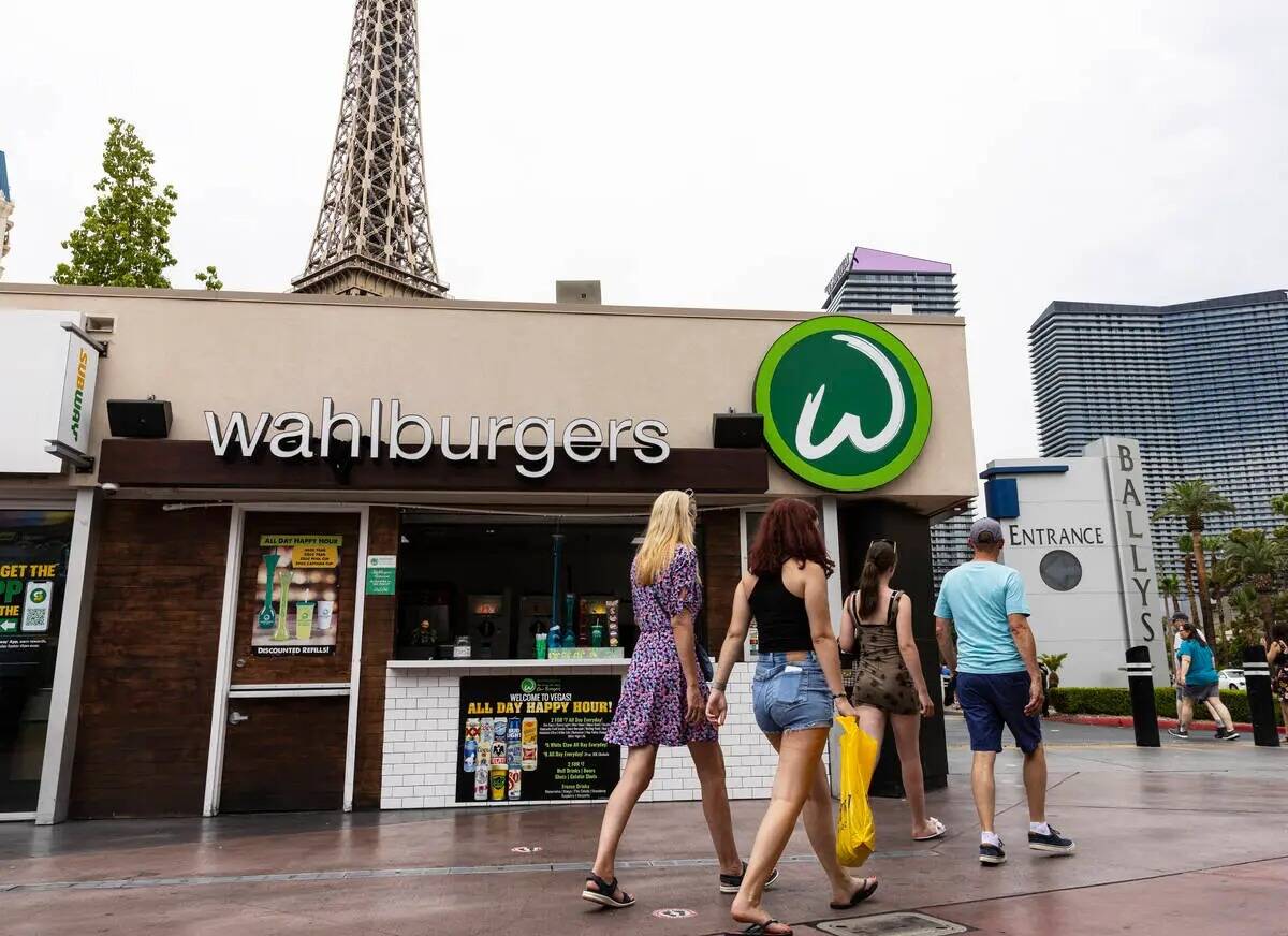 Peatones pasan por delante del restaurante Wahlburgers el martes 26 de julio de 2022, en el Str ...