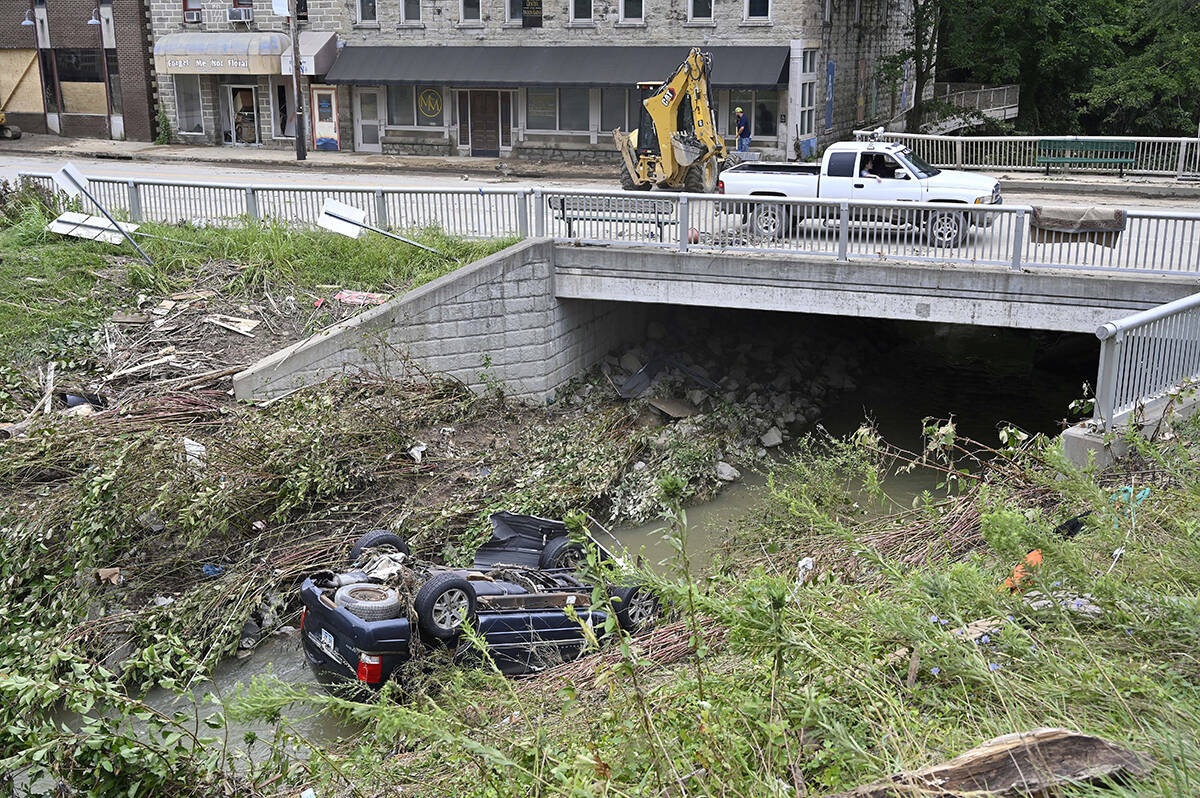 Un automóvil yace volcado en Troublesome Creek en el centro de Hindman, Kentucky, el domingo 3 ...