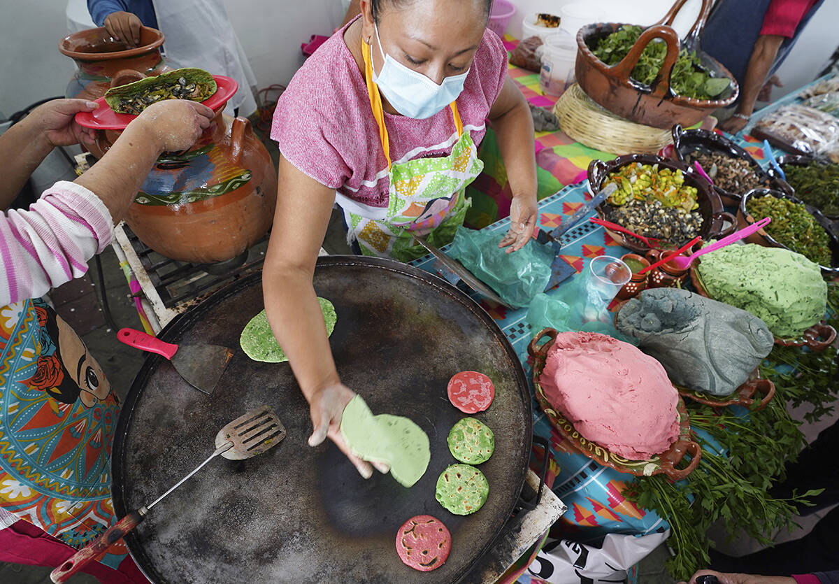 Una vendedora prepara sopes con masa de colores en la Feria de Comida Prehispánica en la deleg ...