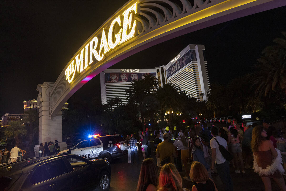 Peatones caminan fuera del hotel y casino Mirage mientras la Policía Metropolitana investiga t ...