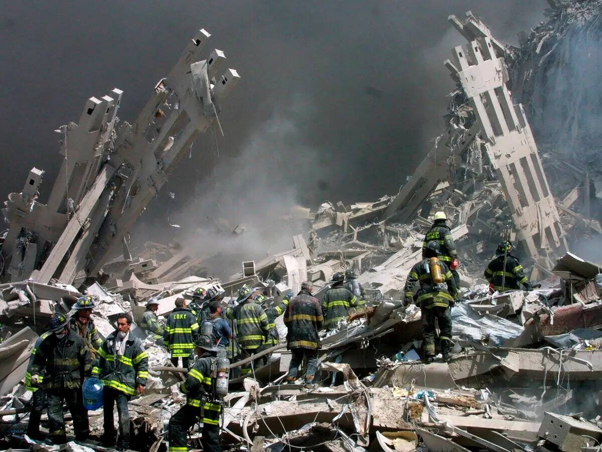 ARCHIVO - Los bomberos se abren paso entre los escombros después de que dos aviones se estrell ...