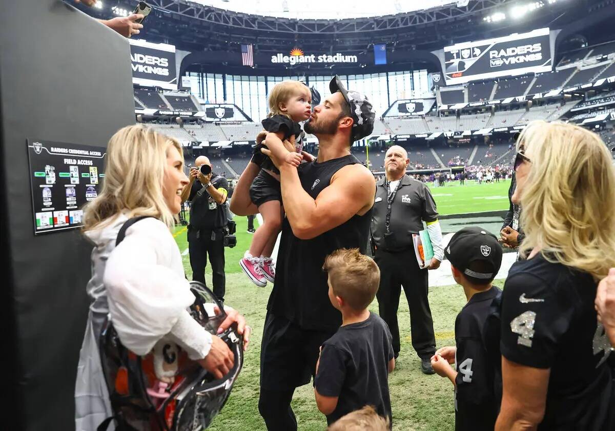 El quarterback de los Raiders, Derek Carr, besa a su hija Brooklyn mientras visita a su familia ...
