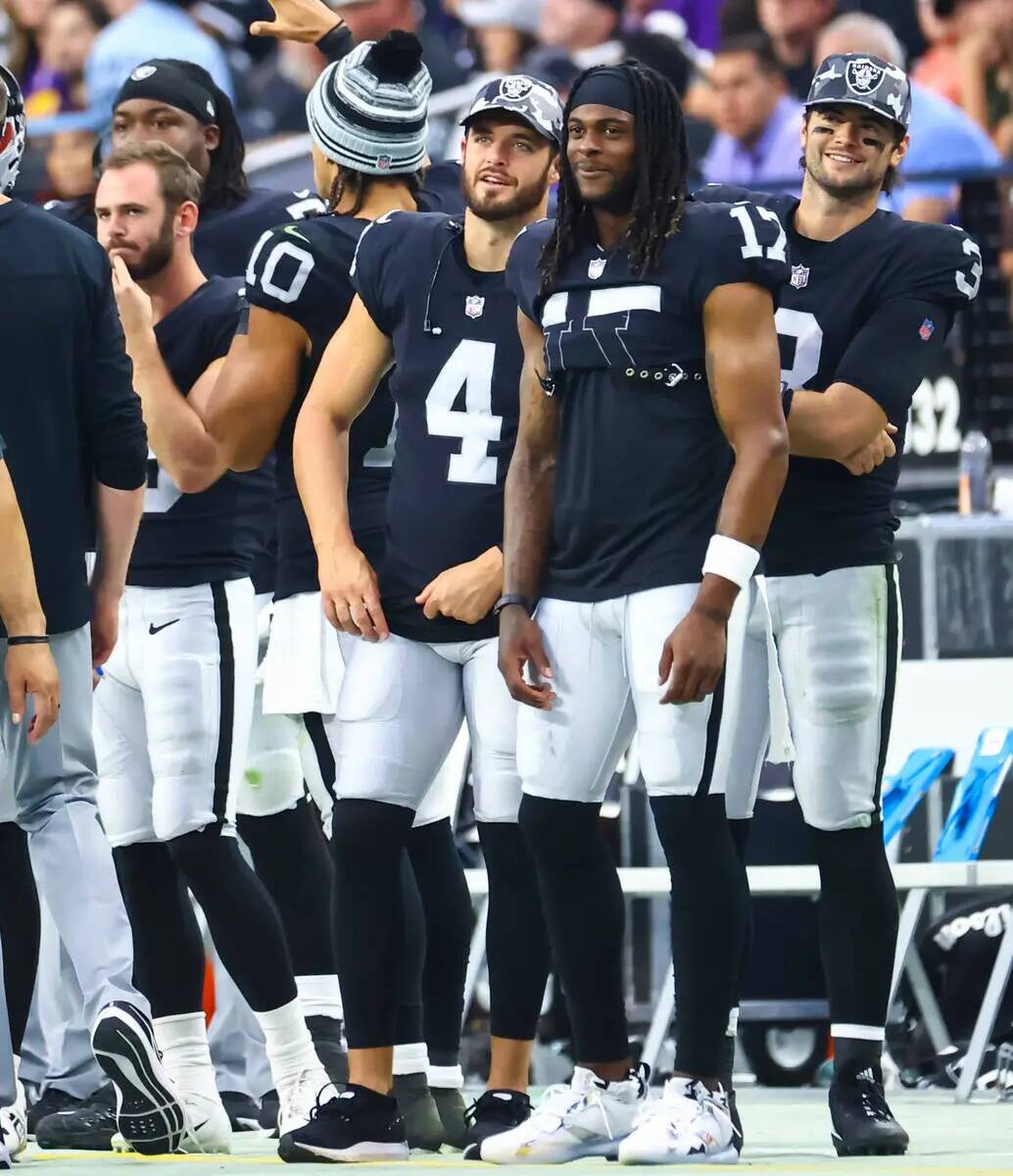 El quarterback de los Raiders, Derek Carr (4), y el wide receiver Davante Adams observan durant ...
