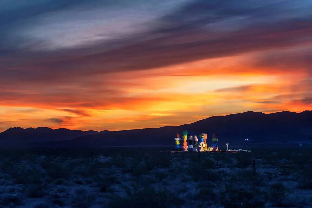 Las luces de trabajo iluminan Seven Magic Mountains al amanecer mientras la instalación de art ...