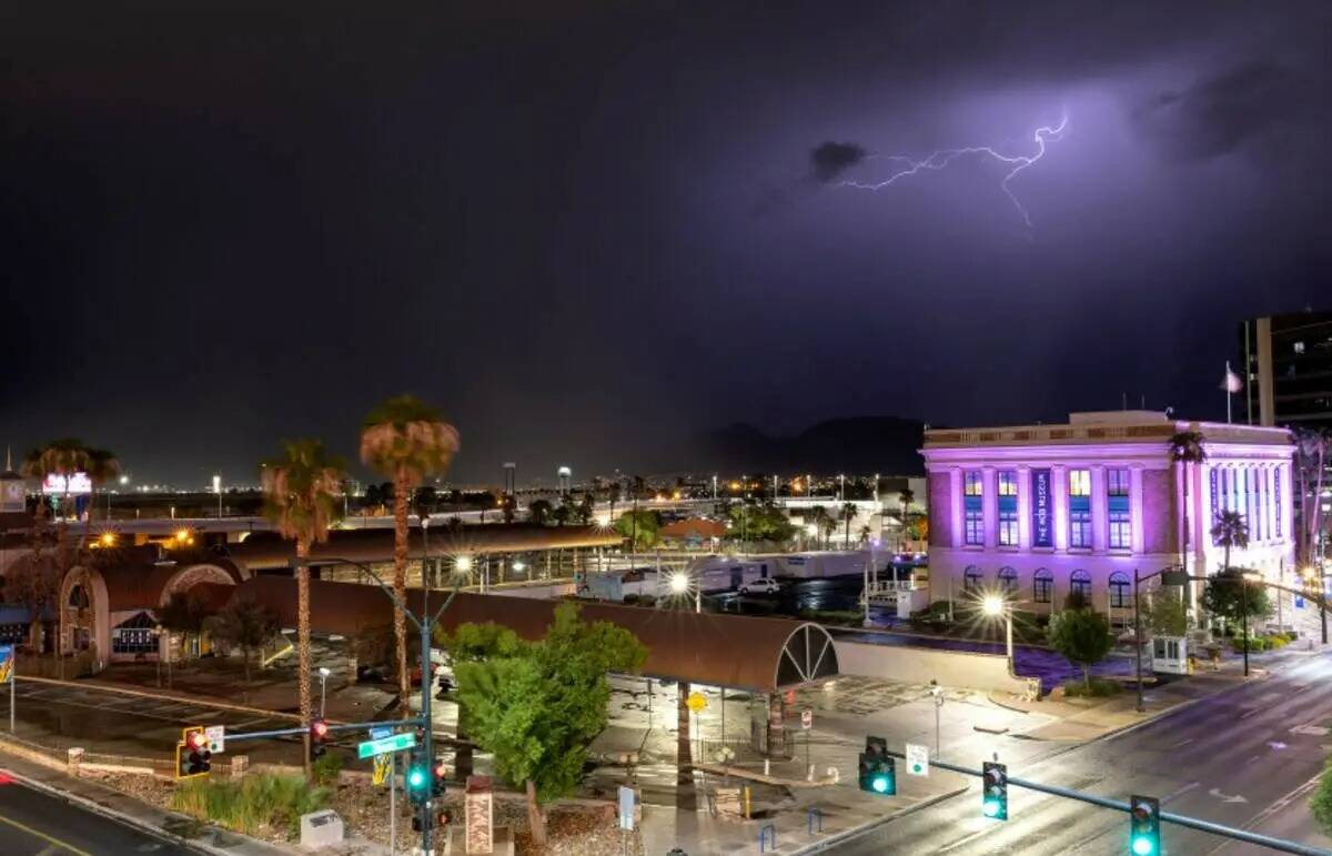 Se ven relámpagos detrás del Mob Museum mientras las tormentas eléctricas se mueven por el v ...