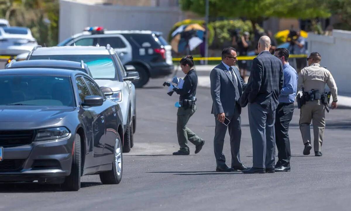 Un investigador de la escena del crimen de la policía de Las Vegas toma fotos mientras otros o ...