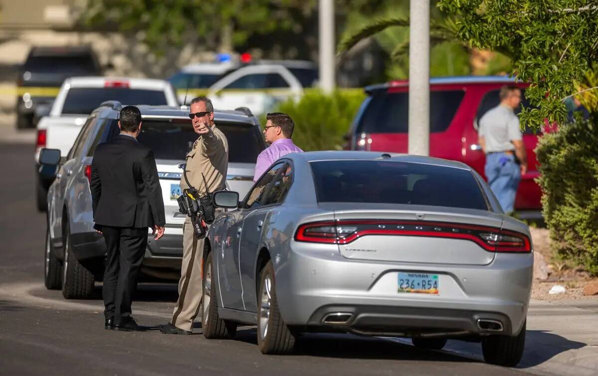 Un oficial de policía de Las Vegas y detectives de homicidios hablan cerca de la casa de Rober ...