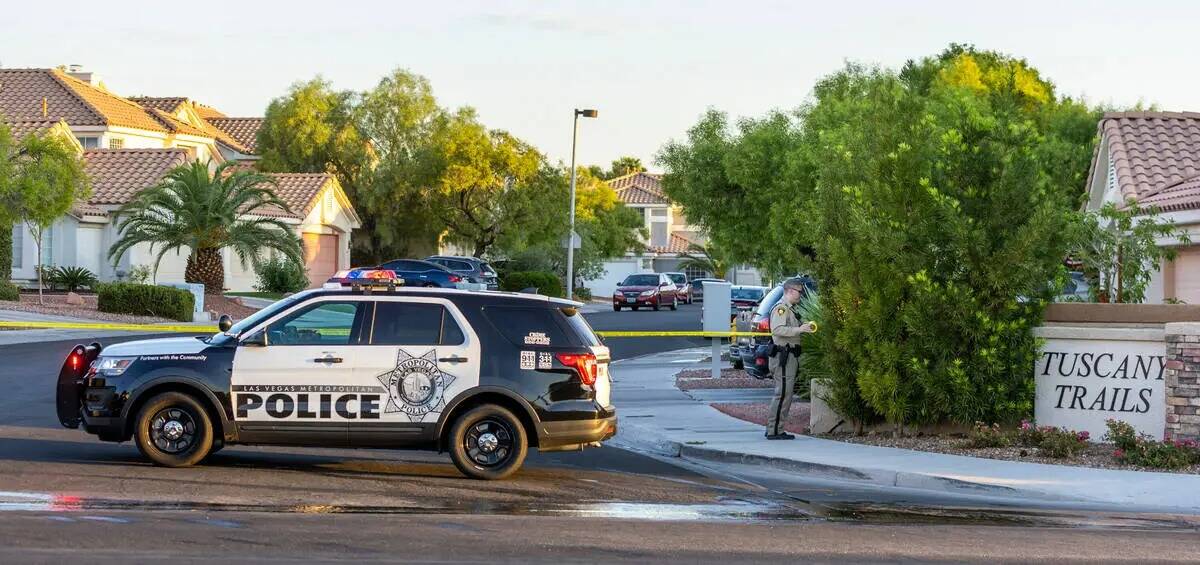 Un oficial de policía de Las Vegas bloquea la entrada al vecindario Tuscany Trails y la casa d ...