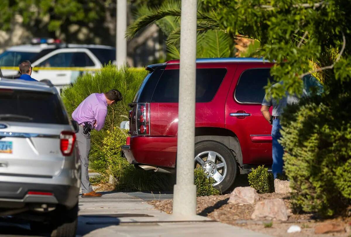 Los detectives de homicidios de la policía de Las Vegas inspeccionan un vehículo en la casa d ...