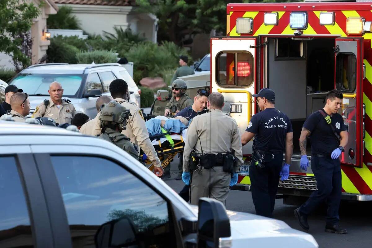 La policía de Las Vegas y el personal de emergencia escoltan al administrador público del Con ...
