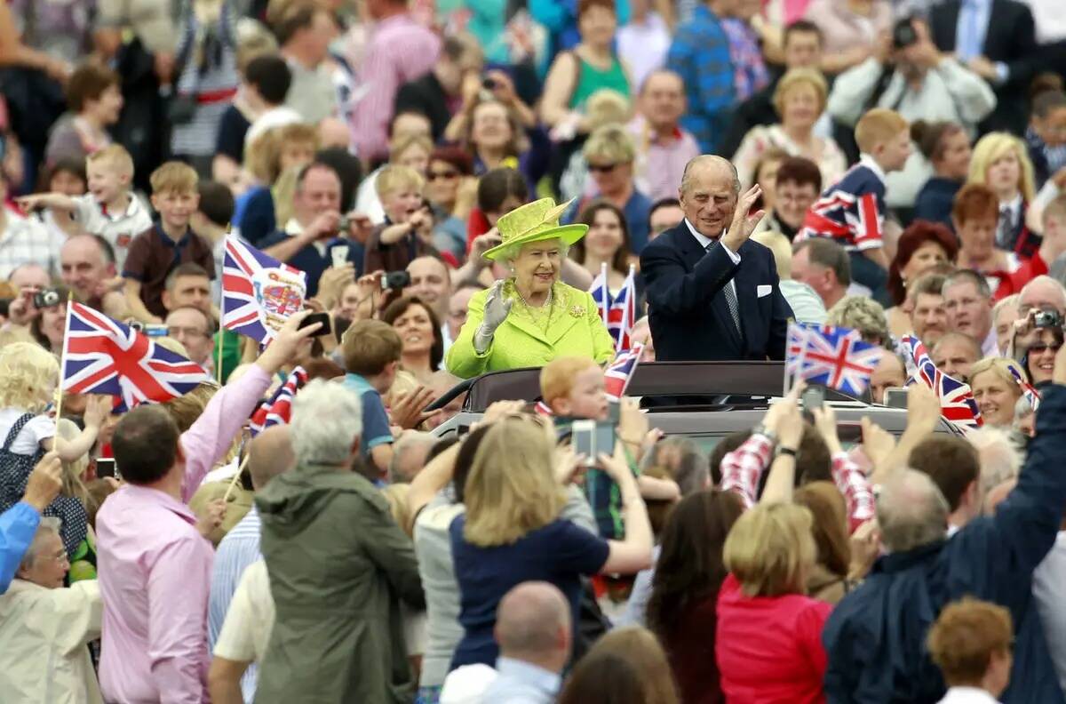 La reina Isabel II de Inglaterra y el príncipe Felipe saludan a miles de personas en el estado ...