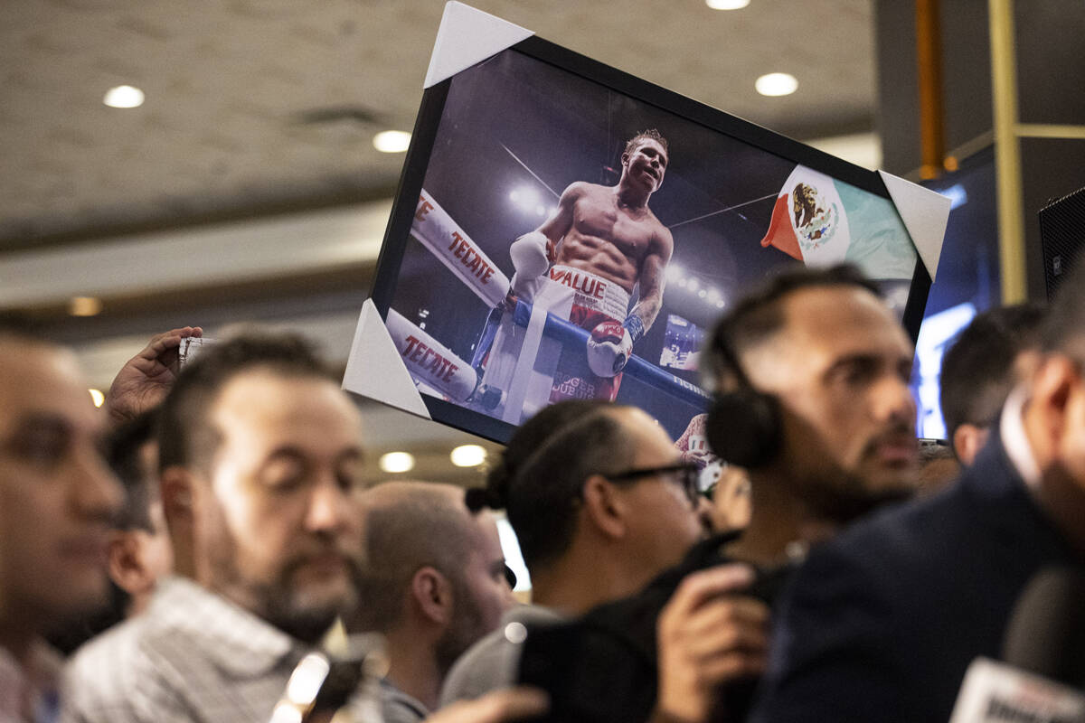 Fanático sostiene foto de Saúl "Canelo" Álvarez durante evento en el hotel y casino MGM Gran ...